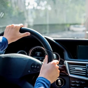 Hands on steering wheel navigating dashboard for responsible and defensive driving training