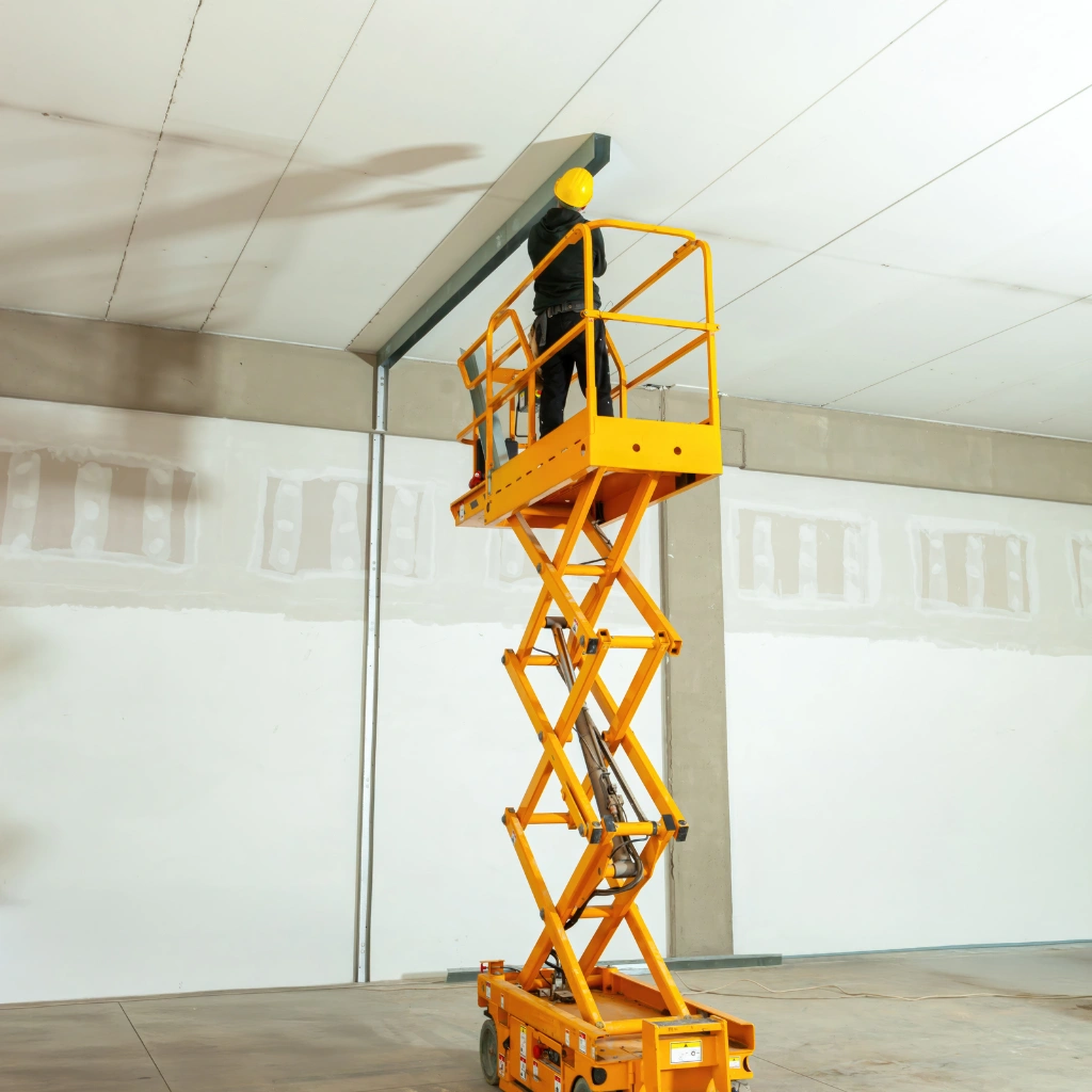 Employee working on scissor lift wearing full safety gear during Elevated Work Platform training
