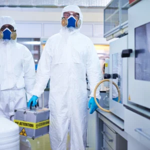 Worker handling chemicals with PPE during WHMIS compliance and safety training